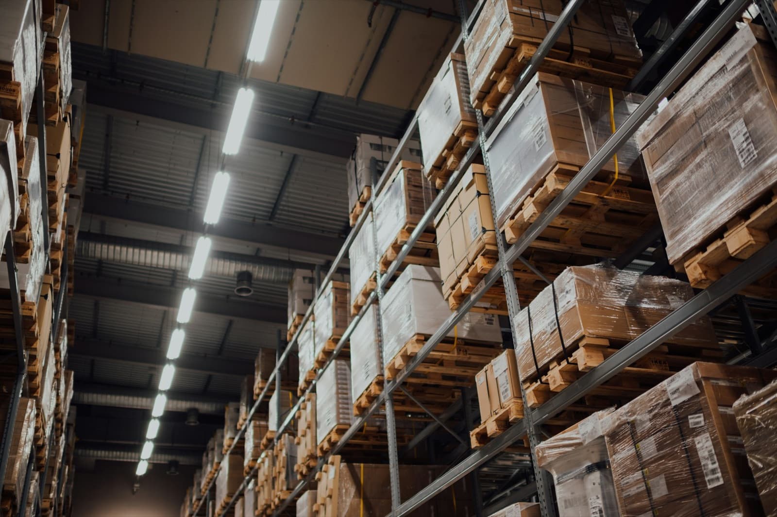 Pallet racking in a distribution warehouse, cartons shrink-wrapped and labelled.